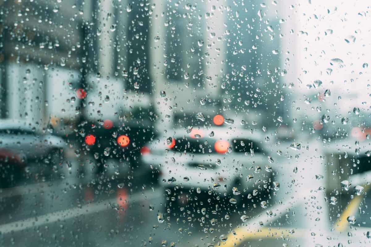 Trafic urbain flou vu à travers une fenêtre avec des gouttes de pluie, une scène parfaite pour un jour de pluie.