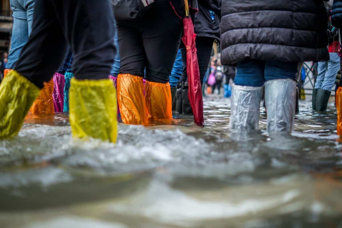 des gens portant des bottes lors d'une inondation
