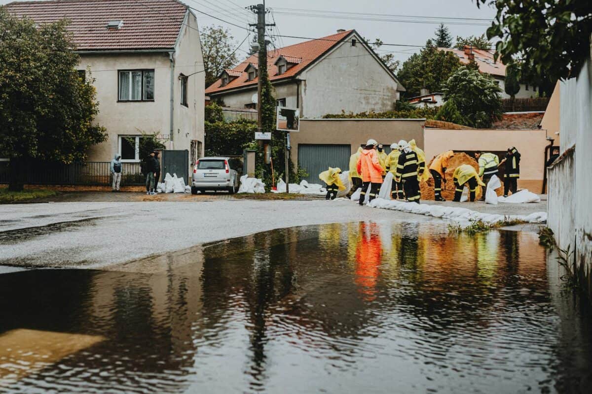 Les intervenants d'urgence en tenue réfléchissante s'attaquent aux eaux de crue dans une rue résidentielle.