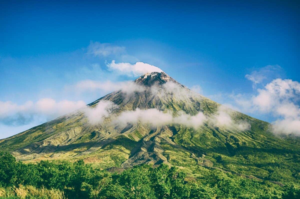 Vue imprenable sur le volcan Mayon entouré de ciel bleu et de nuages à Bicol, Philippines.